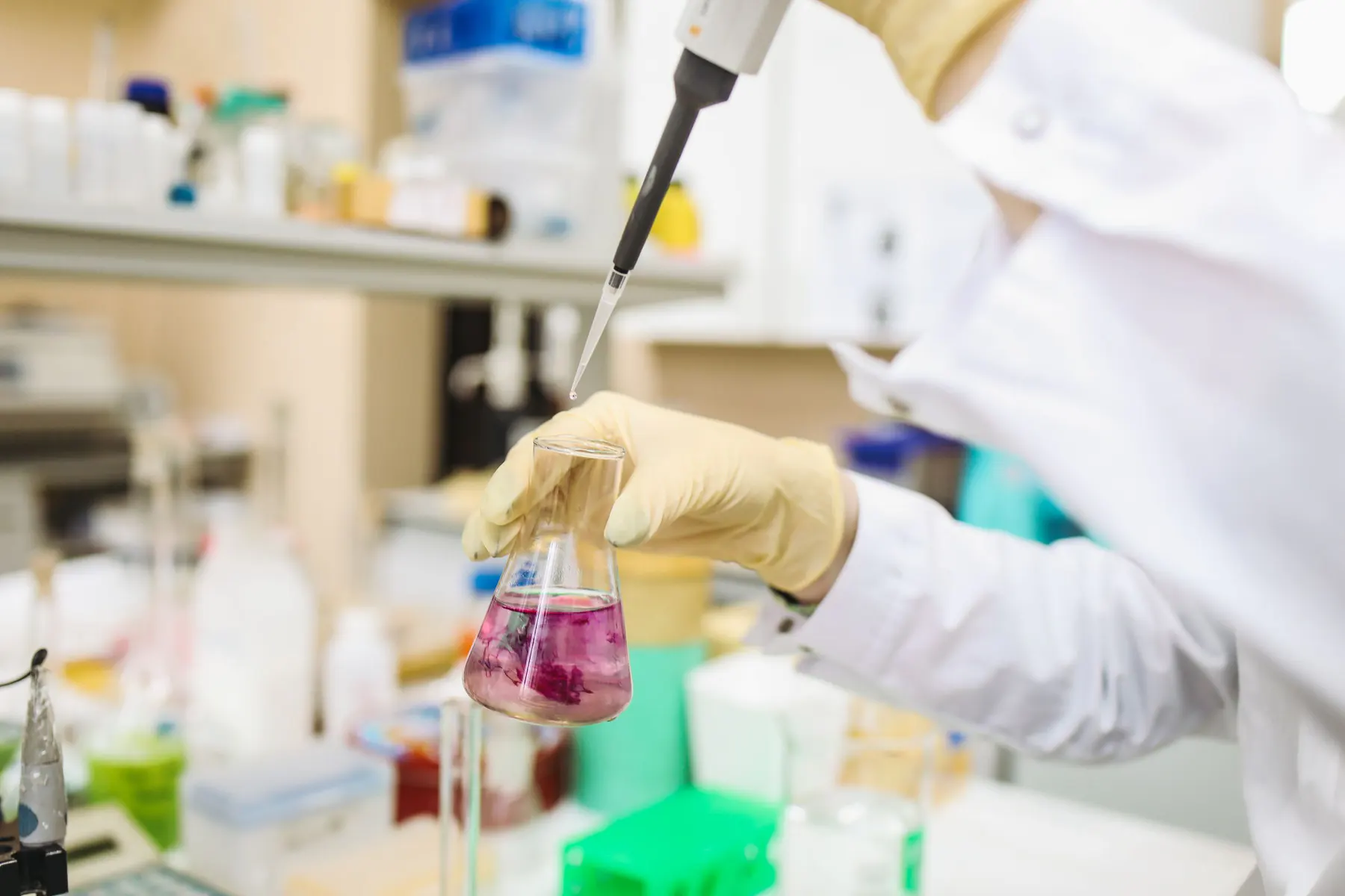 Scientist dispensing a formulation sample into laboratory glassware