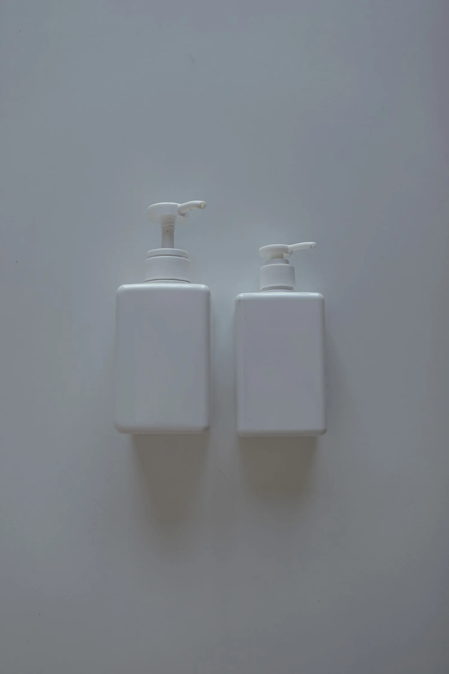 Two blank white pump bottles arranged for a skincare brand