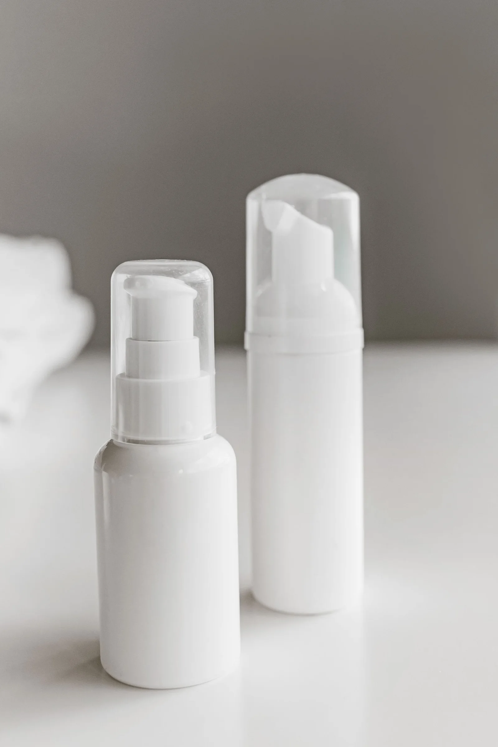 Two unbranded white pump bottles prepared for private label packaging