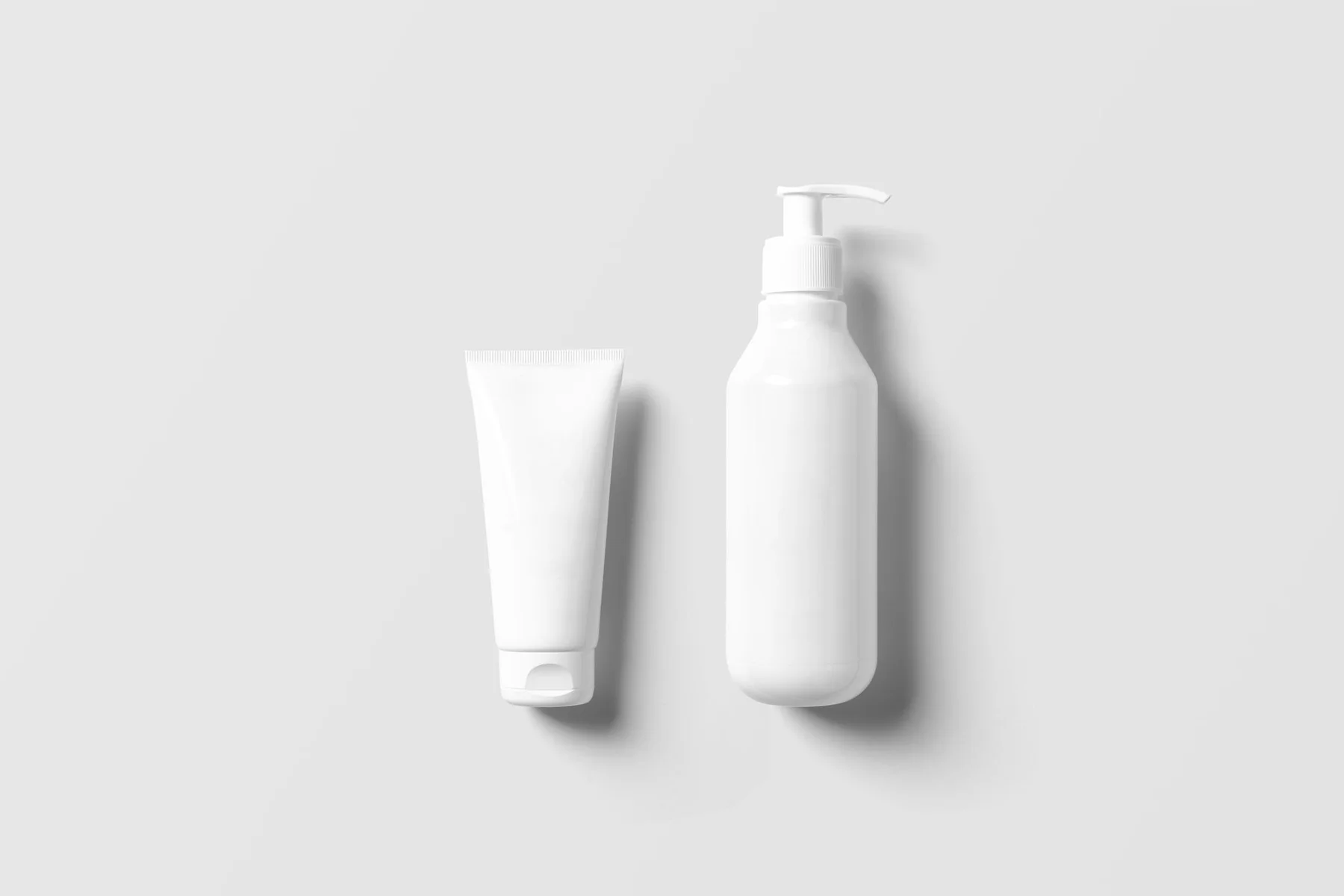 Unbranded cosmetic tube and pump packaging on a clean white surface